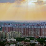 Captivating aerial view of Noida's residential skyline at sunrise, showcasing modern architecture and dramatic skies.