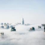 A stunning view of Dubai skyscrapers emerging through a blanket of fog, showcasing modern architecture.